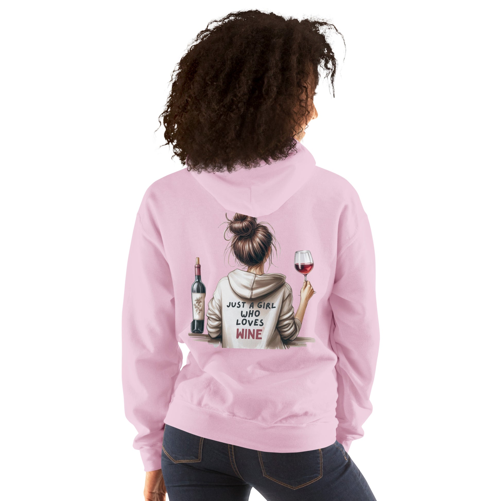 A woman wears the "Just a Girl who Loves Wine Hoodie" in light pink, with a back illustration of a girl holding a wine glass next to a bottle, and the text "Just a girl who loves wine.