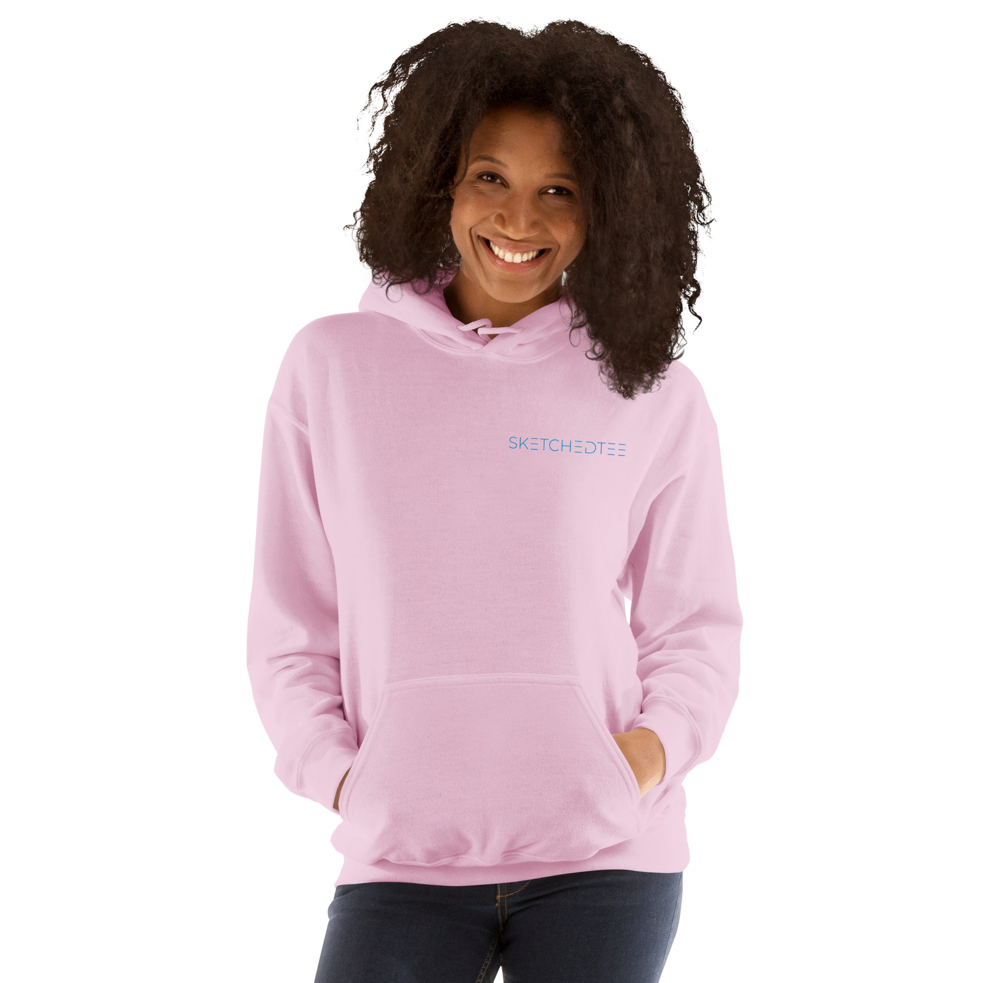A woman with curly hair smiles while wearing the "Just a Girl who Loves Wine" hoodie, a cozy light pink sweatshirt. She stands with her hands in the front pocket against a white background.