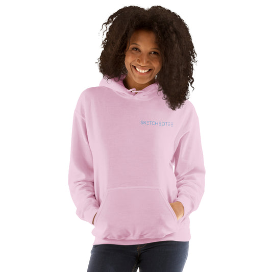 A woman with curly hair smiles while wearing the "Just a Girl who Loves Wine" hoodie, a cozy light pink sweatshirt. She stands with her hands in the front pocket against a white background.