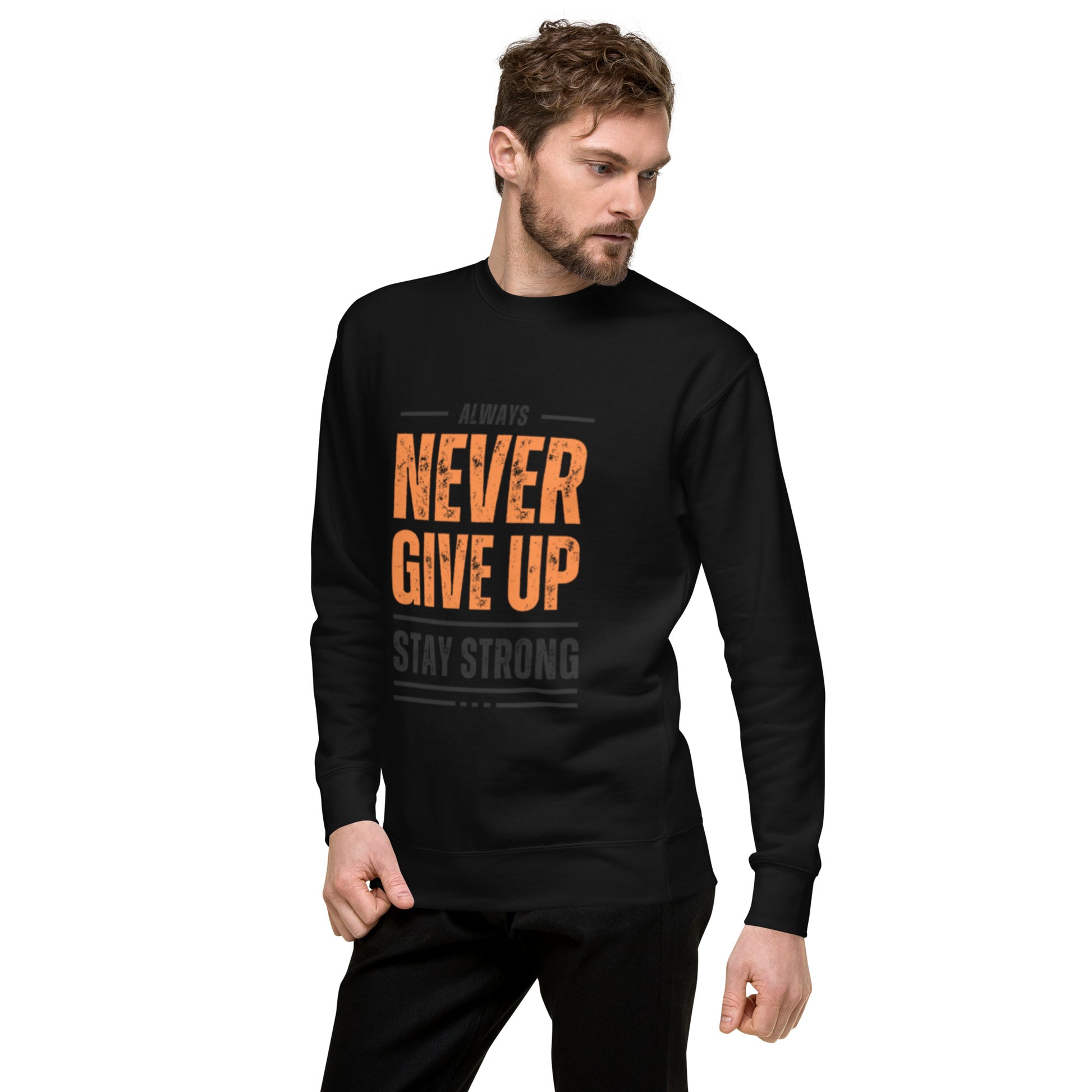 A man models the Never Give Up Unisex Premium Sweatshirt, featuring motivational text and a modern streetwear vibe, as he stands against a white background with one hand in his pocket.